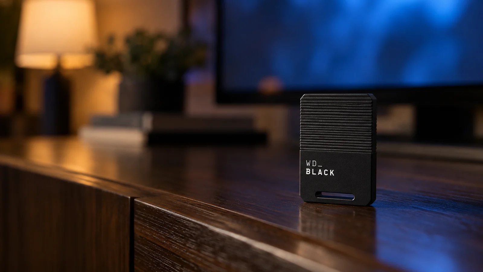 WD_BLACK C50 expansion card standing on a dark media cabinet in front of a softly lit TV