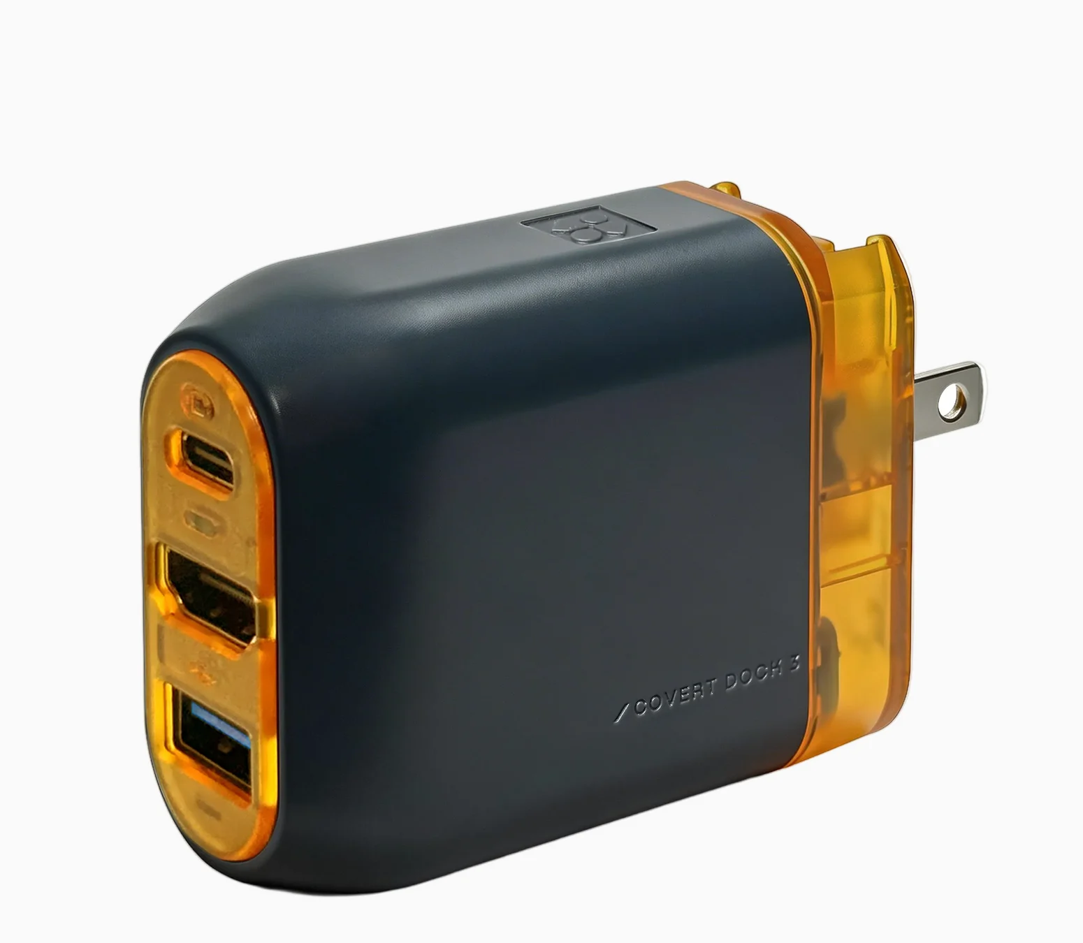 Dark gray Genki Covert Dock 3 with an orange translucent end showing USB-C, HDMI and USB-A ports, and folding US plug prongs